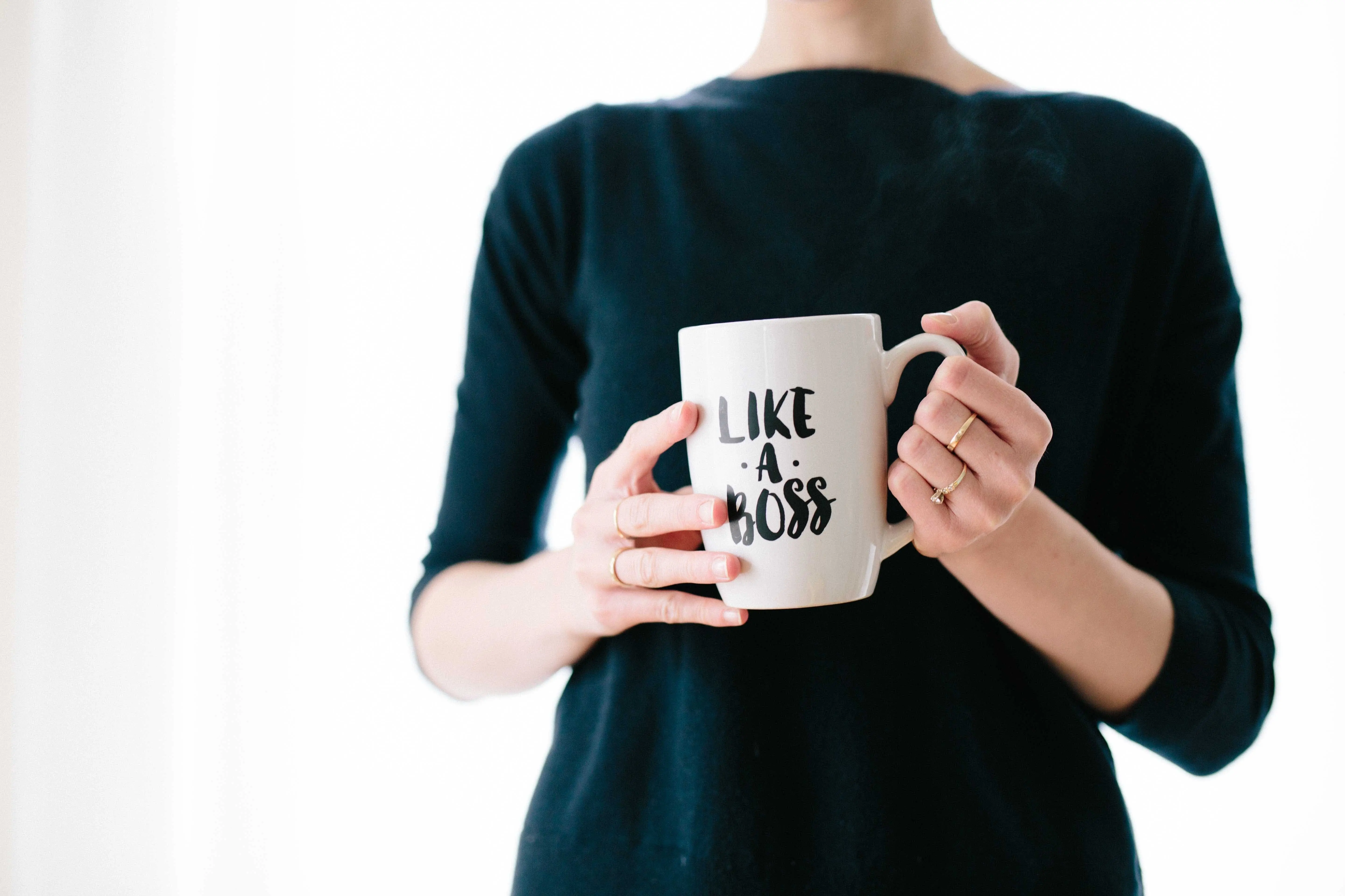 woman leader holding white mug while standing