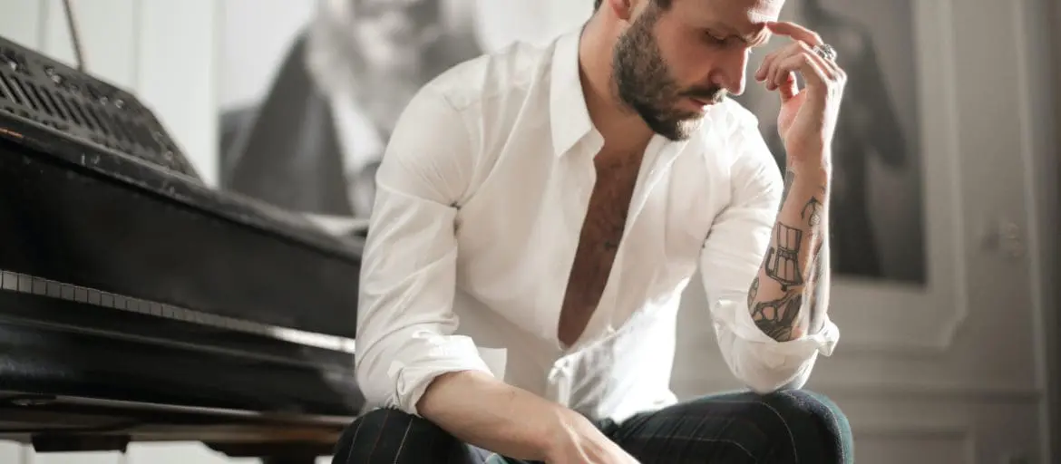 man sitting at a piano making a decision