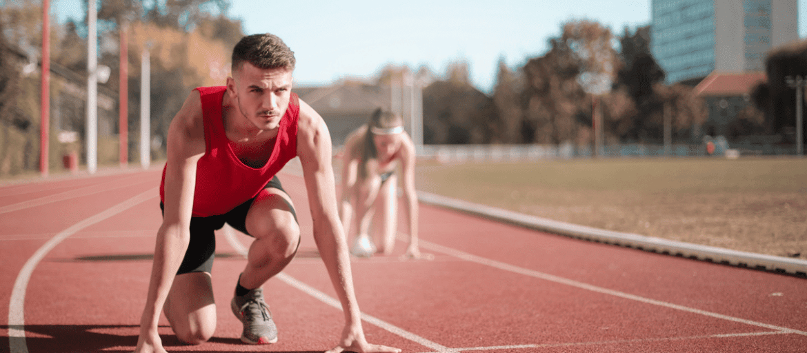 Man about to start running on a track field