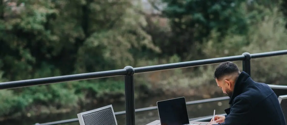 Man working with a laptop in an outdoor cafe