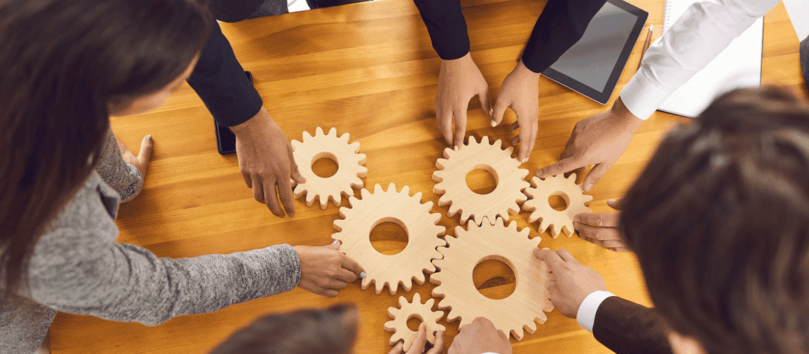 Team working with wooden gears on a meeting table