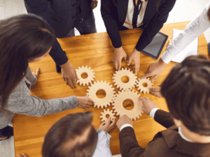 Team working with wooden gears on a meeting table